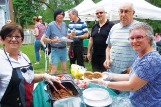staff at Community Living North Frontenac Deb Ryckman and Estelle Dicintio served up hot beef on a bun to guests at their annual community BBQ that took place in Sharbot Lake on May 27